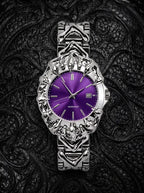 Razorclaw Gothic Watch, purple dial and sculpted silver-tone claw case, flat lay on patterned black fabric