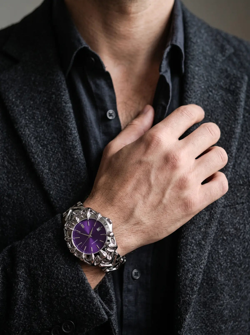 Razorclaw Gothic Watch, purple-dial watch worn on a raised wrist against a charcoal shirt