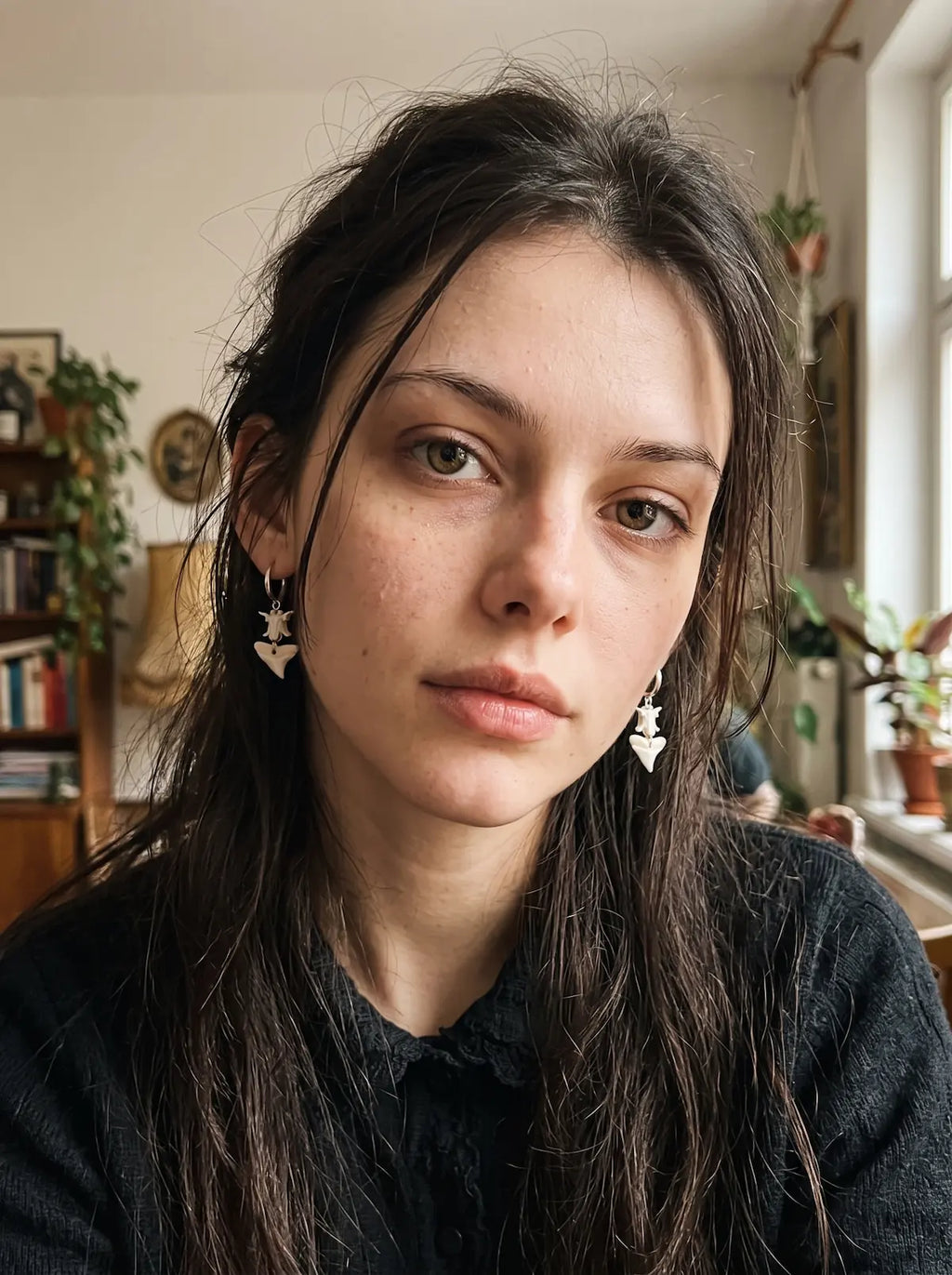 Riptide bull shark tooth and snake bone earrings worn as a pair in a front-facing portrait