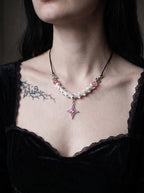 Roselight Snake Bone Necklace, pale vertebrae necklace with pink beads worn above a black velvet neckline