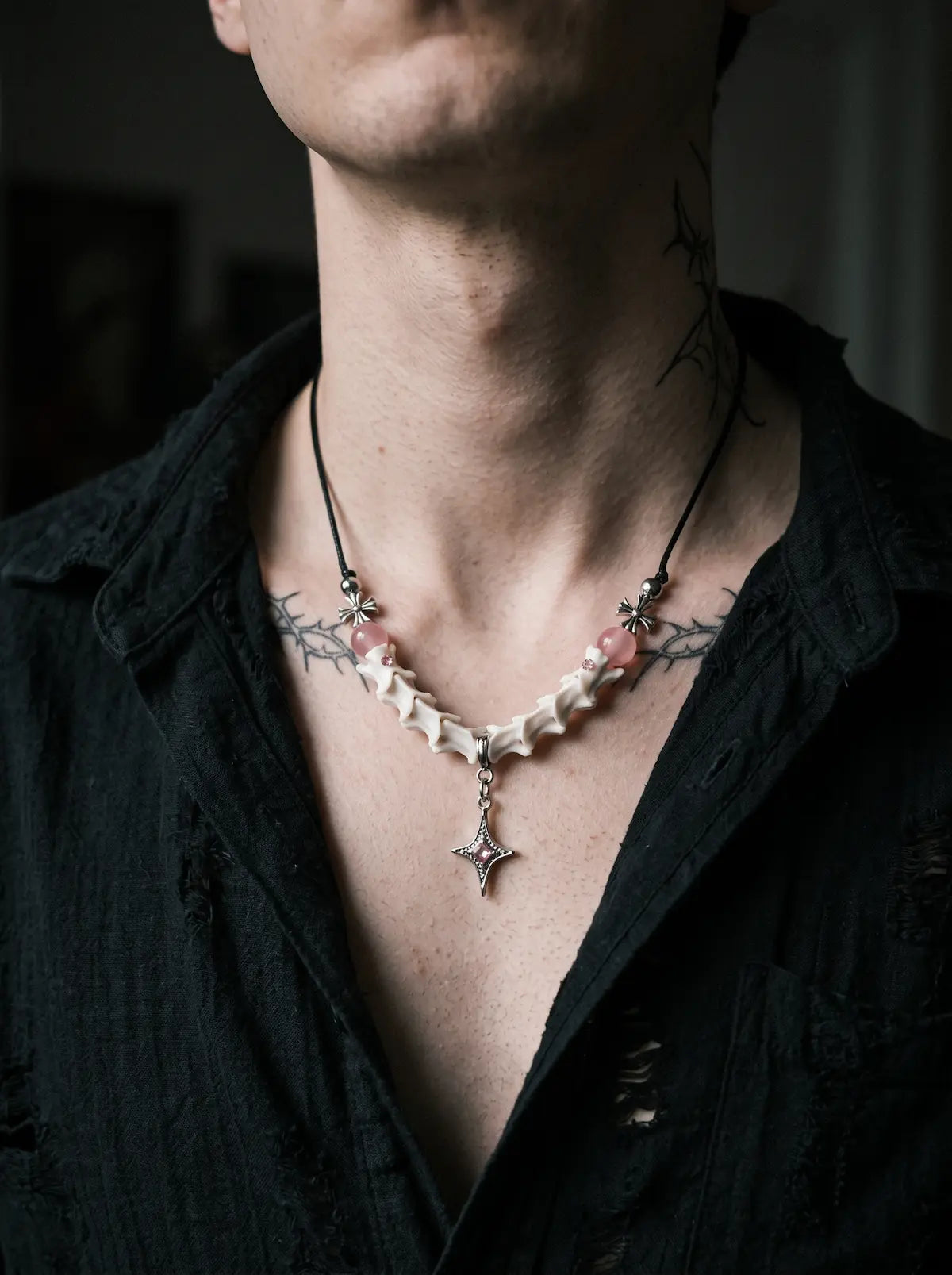 Roselight Snake Bone Necklace, close neck view of pink accent beads and silver-tone pointed pendant
