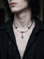 Sablecoil Snake Bone Necklace, pale bone and silver serpent necklace worn against an open black shirt