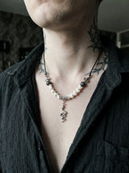 Sablecoil Snake Bone Necklace, close view of white vertebrae necklace with small dark beads and snake charm