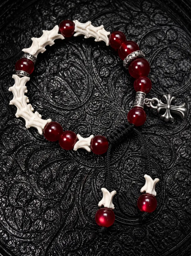 Scarlet Cross snake bone bracelet with red beads, engraved silver-tone spacers and a hanging cross on black fabric
