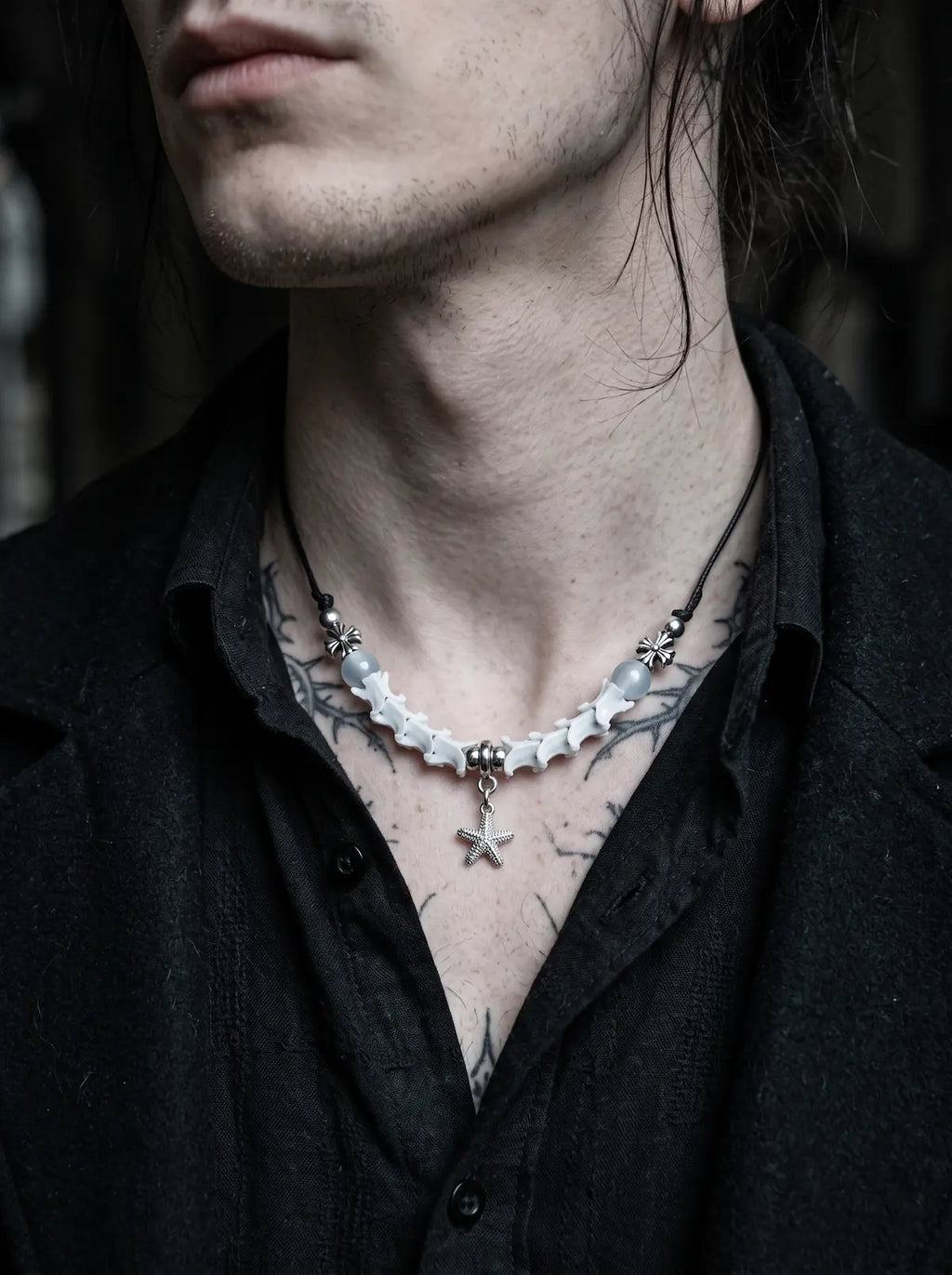 Seafoam Starfish Snake Bone Necklace, pale snake bone and starfish necklace worn above an open dark shirt