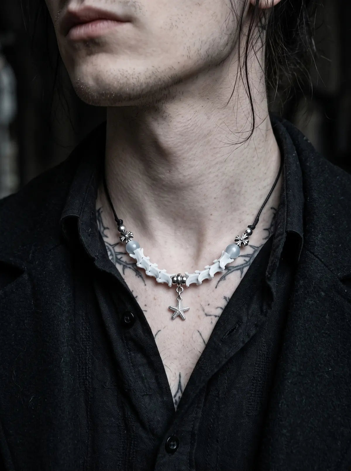 Seafoam Starfish Snake Bone Necklace, pale snake bone and starfish necklace worn above an open dark shirt
