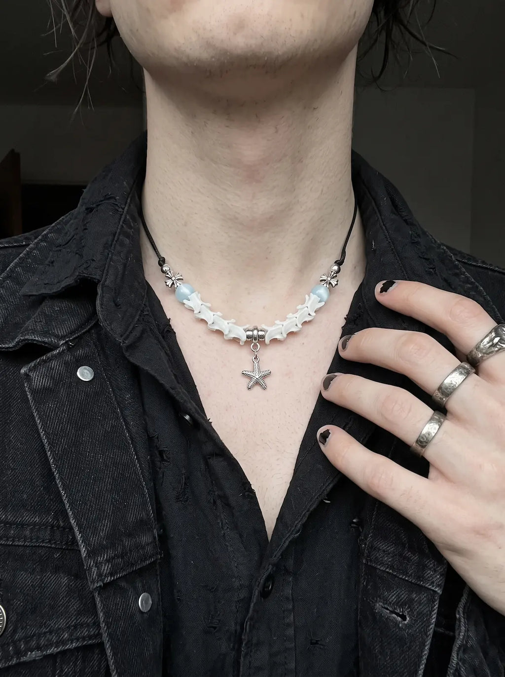 Seafoam Starfish Snake Bone Necklace, white vertebrae and starfish necklace seen on a model in a dark jacket