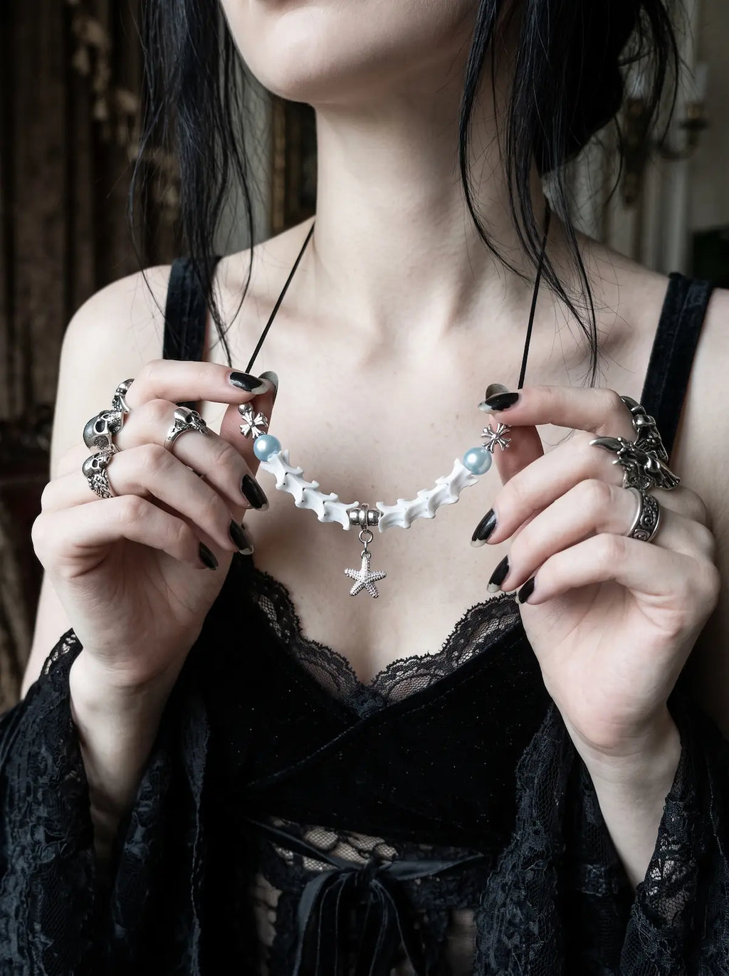 Seafoam Starfish Snake Bone Necklace, close front view of light blue beads and silver-tone starfish charm held in hands