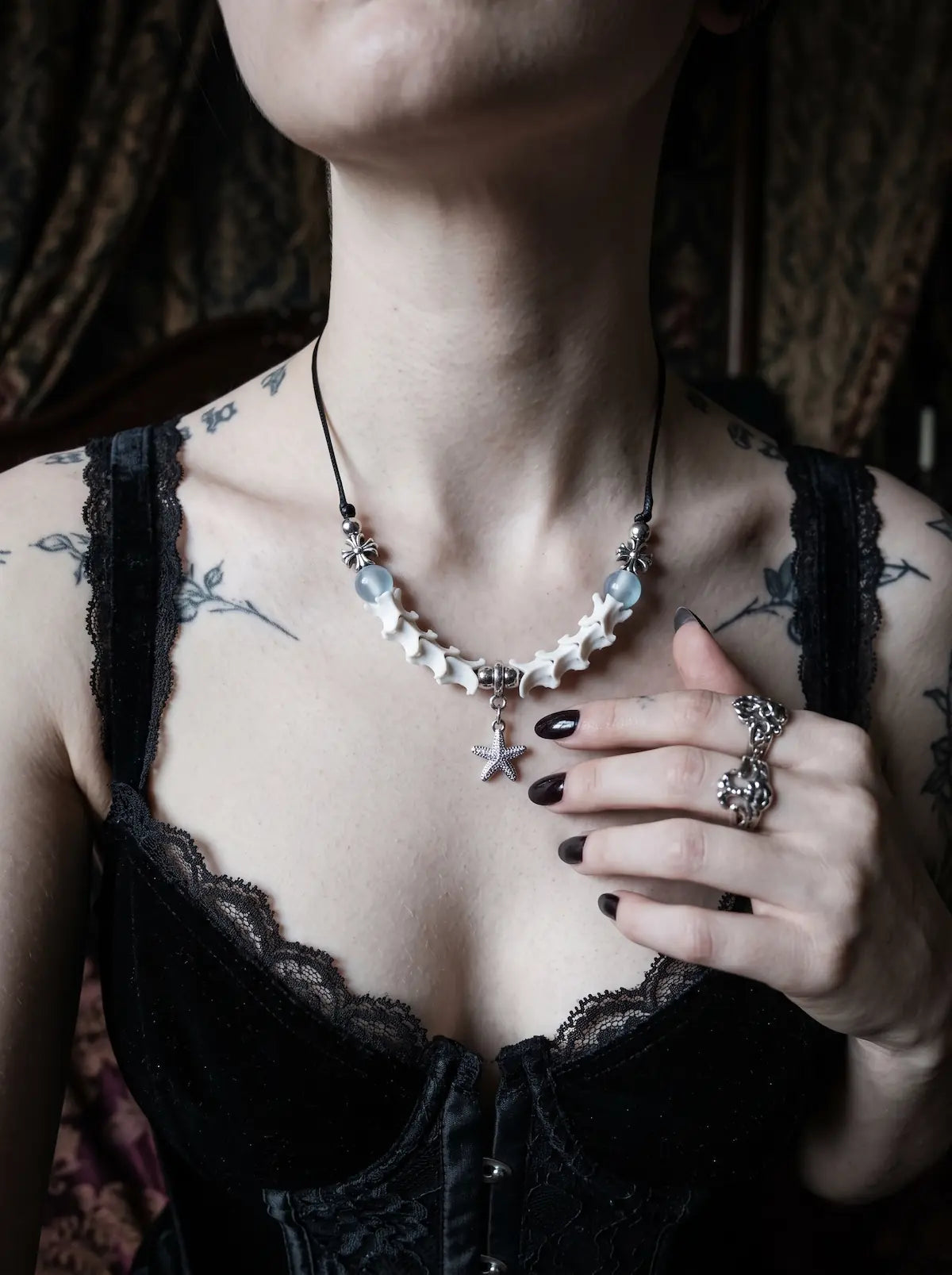 Seafoam Starfish Snake Bone Necklace, close collarbone view of pale snake bone necklace with seafoam-blue accents
