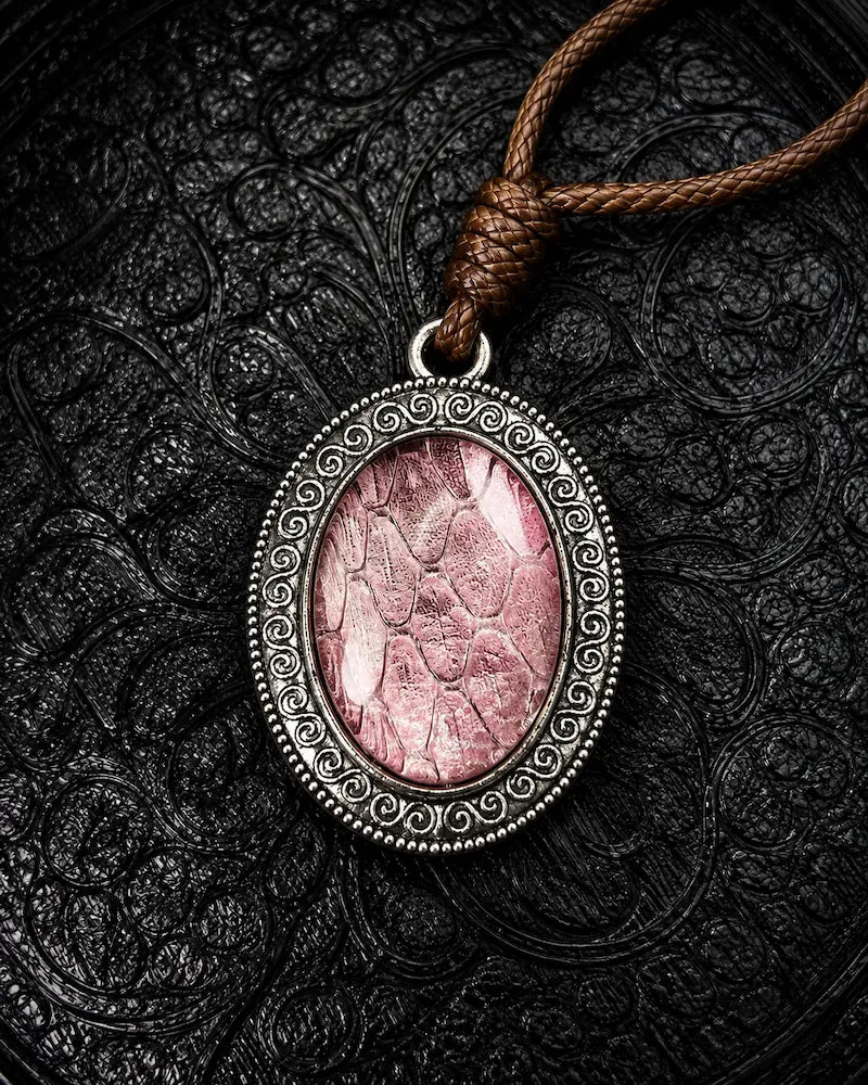 Serpent Relic snakeskin pendant necklace in Dusty Rose, with a silver-tone oval frame and brown braided cord