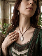 Ivory Serpent Relic snakeskin pendant worn with a green and cream lace-trimmed top