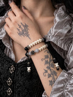 Smoky Rosette snake bone bracelet worn with the hand at the neck, showing two rows and dangling bone-tipped cords