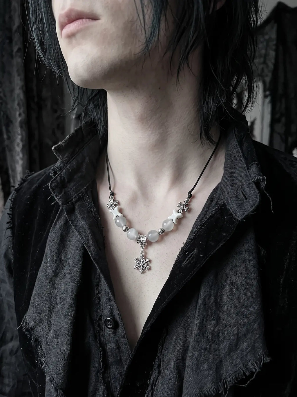 Snowbound Snake Bone Necklace, white snake bone snowflake necklace worn with an open charcoal shirt