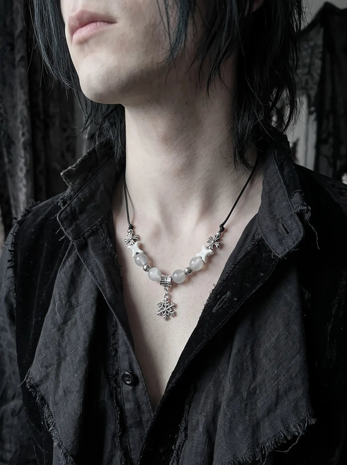Snowbound Snake Bone Necklace, white snake bone snowflake necklace worn with an open charcoal shirt