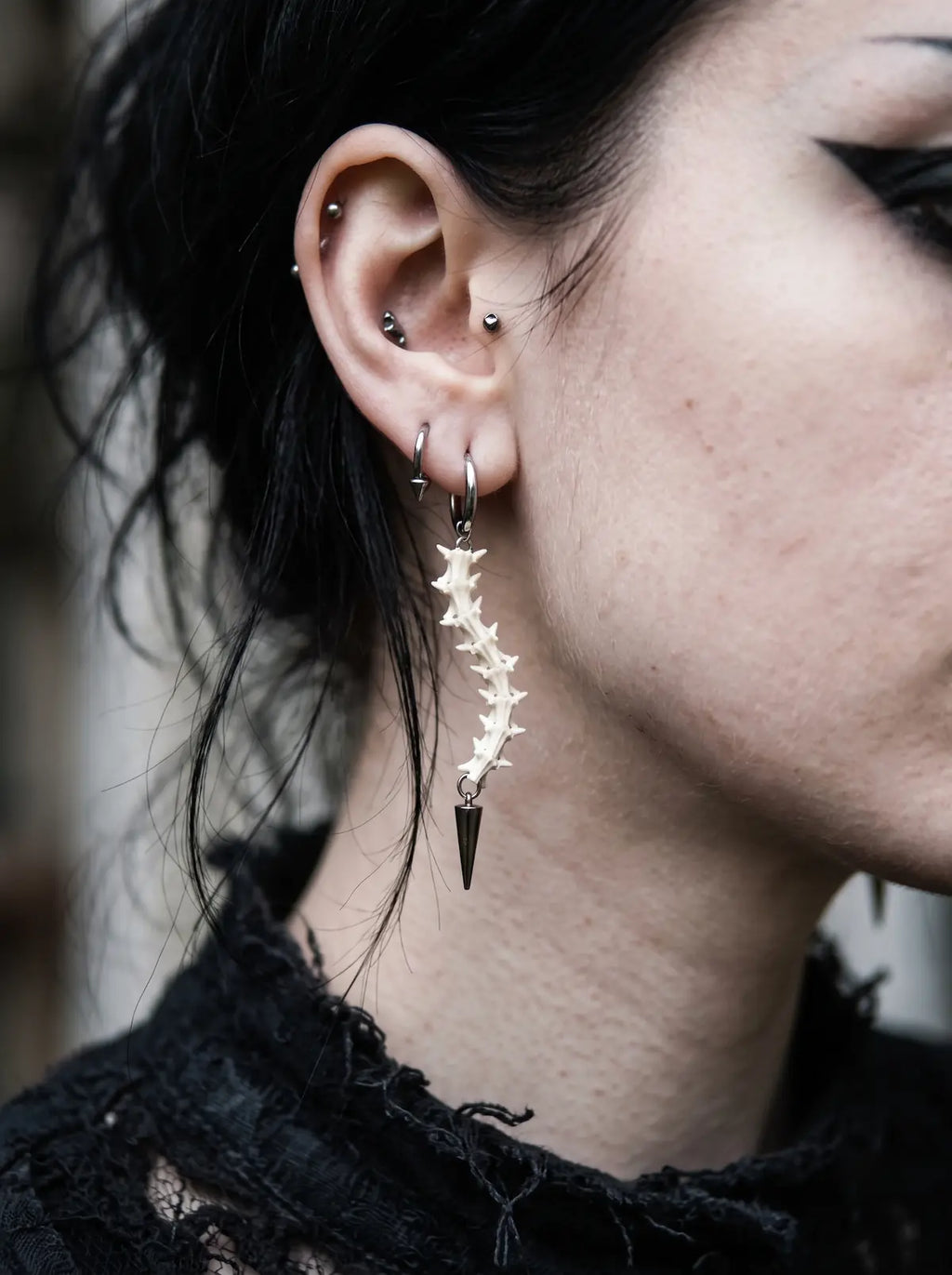 Spinepoint Snake Bone Earrings, long snake bone earring worn from the side with dark spear-shaped tip