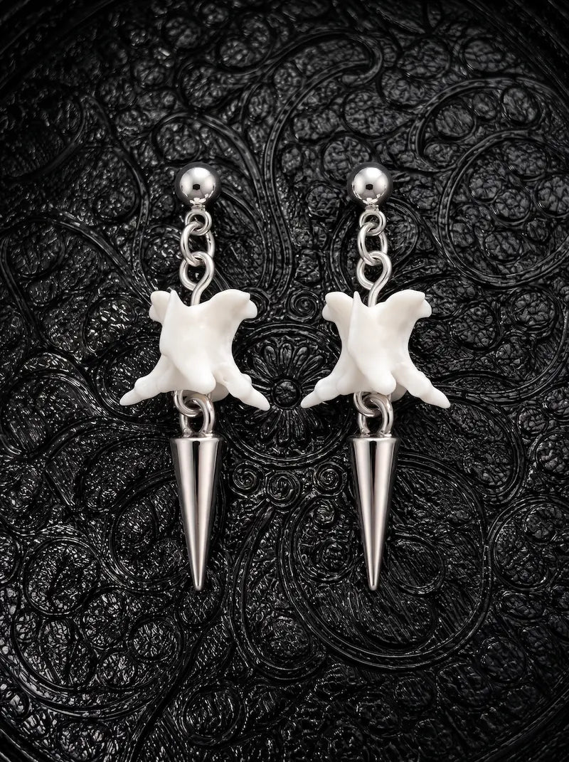 Spire Chain snake bone earrings with short silver-tone spike drops and ball studs, displayed as a pair on black fabric