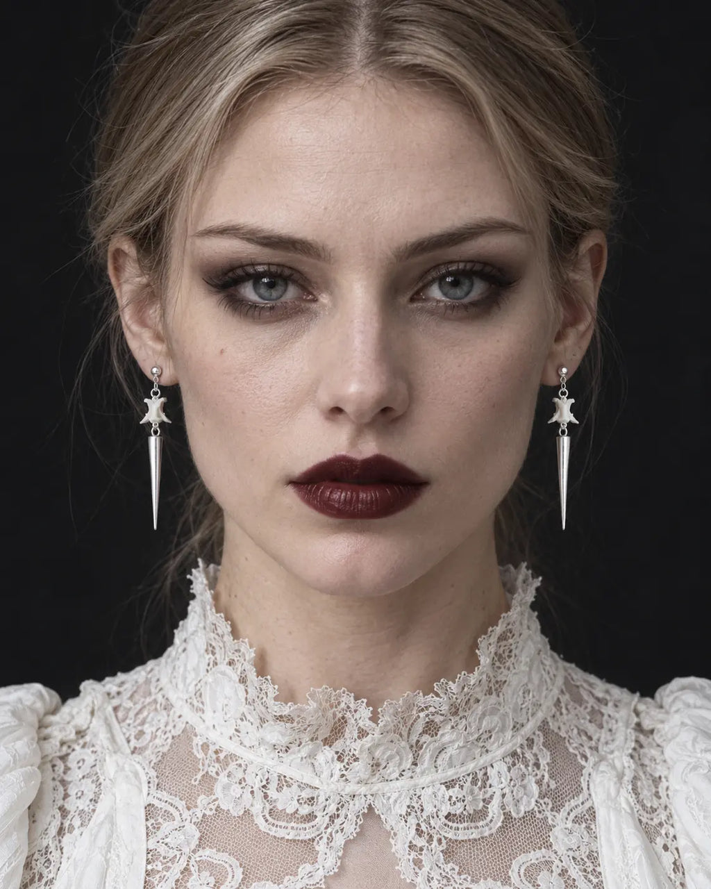 Spire Chain snake bone earrings worn as a pair in a front-facing portrait with a white lace blouse