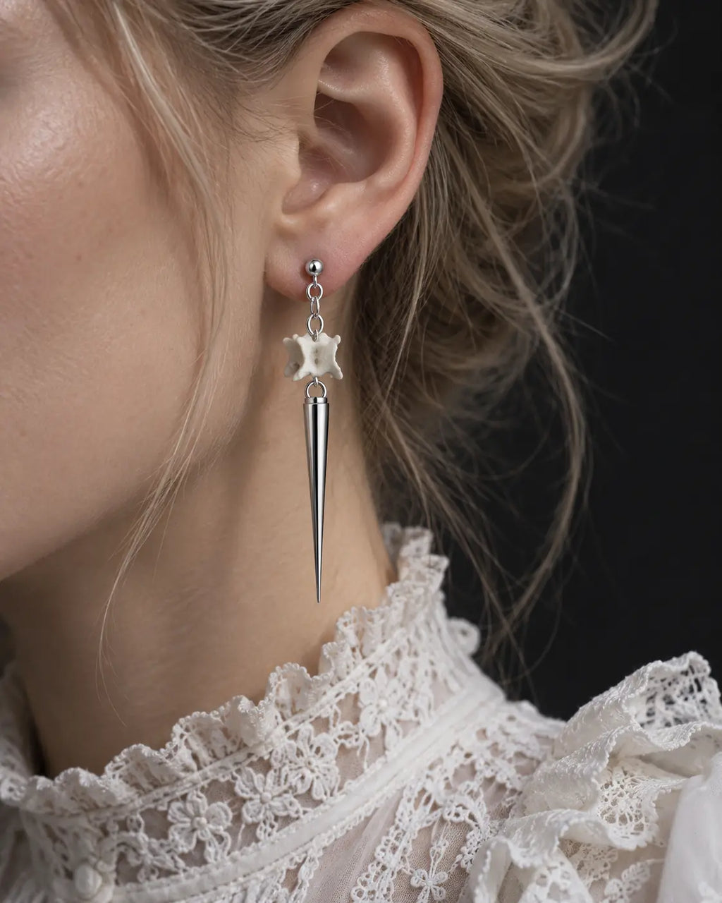 Close-up of a long Spire Chain snake bone earring showing the stud, chain and polished spike