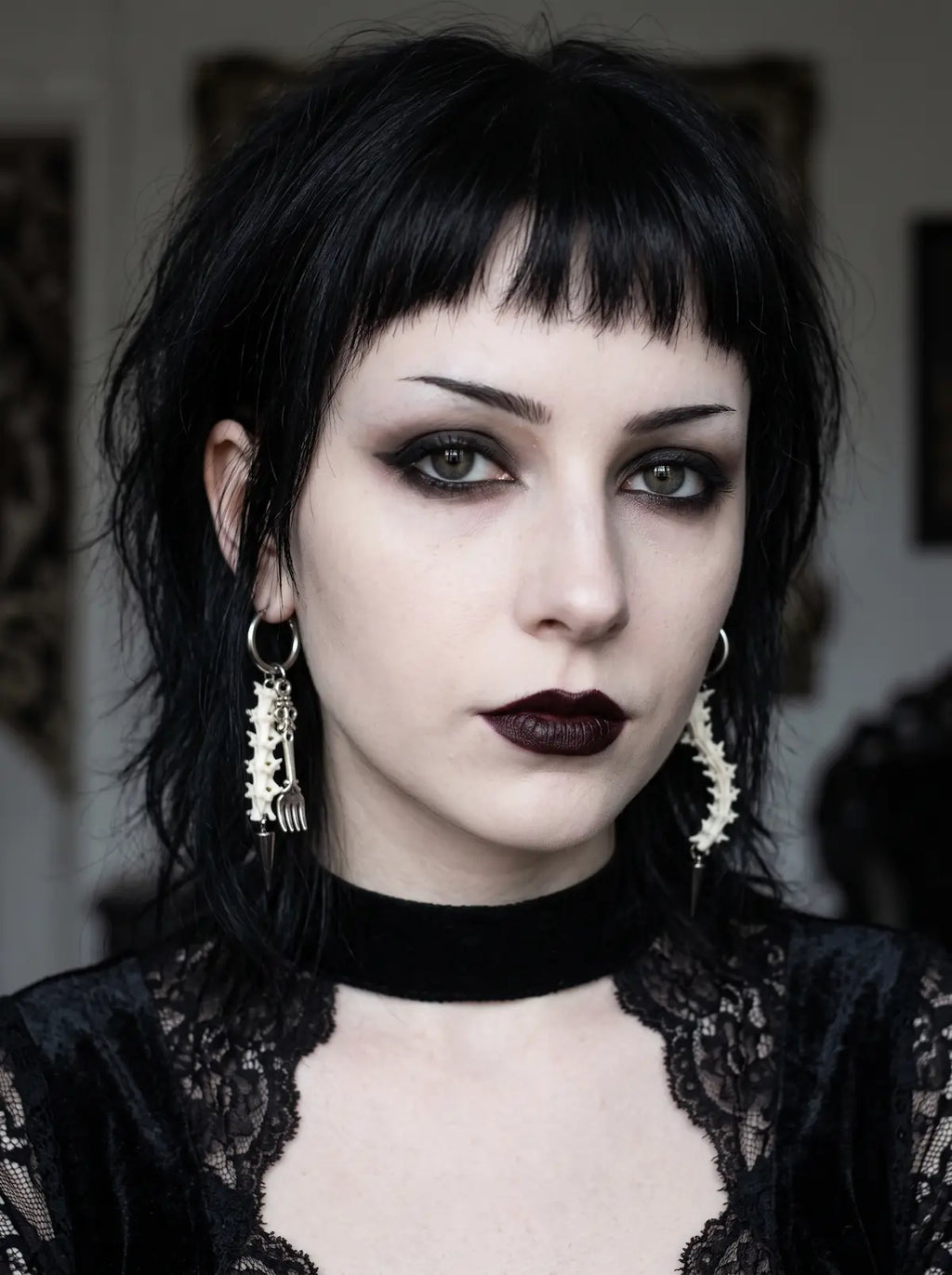 Split Relic Snake Bone Earrings, portrait showing paired vertebrae earrings of different ornate metal accents