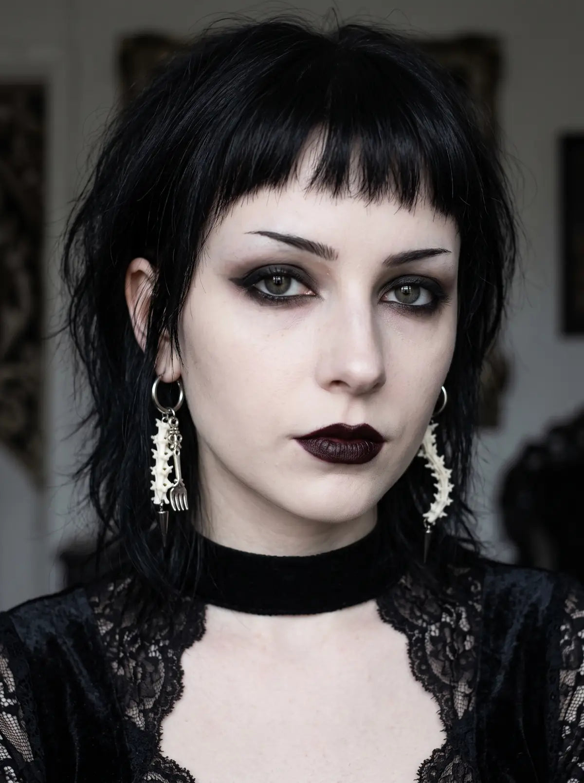 Split Relic Snake Bone Earrings, portrait showing paired vertebrae earrings of different ornate metal accents