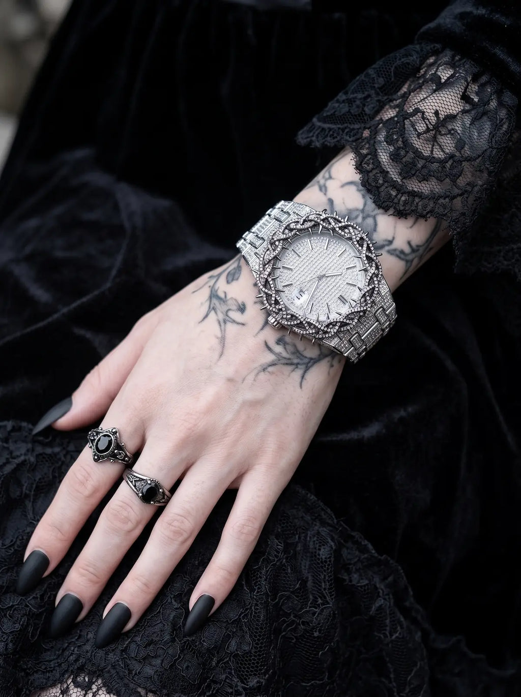 Thorncrown Gothic Watch, pale-dial thorn-bezel watch on a tattooed wrist with a black lace sleeve