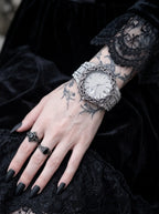 Thorncrown Gothic Watch, pale-dial thorn-bezel watch on a tattooed wrist with a black lace sleeve