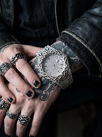 Thorncrown Gothic Watch, silver gothic watch on a wrist beside rings and dark-painted nails