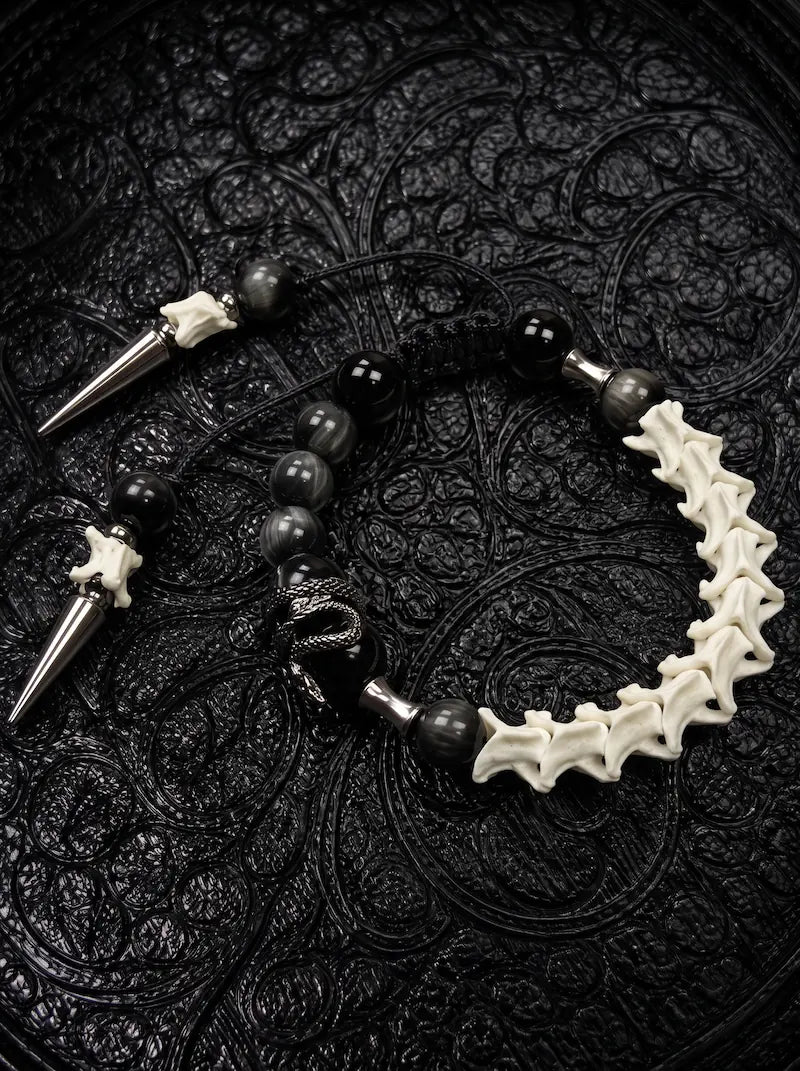 Twin Spike snake bone bracelet with black and gray beads, a coiled snake charm and two polished silver-tone spikes