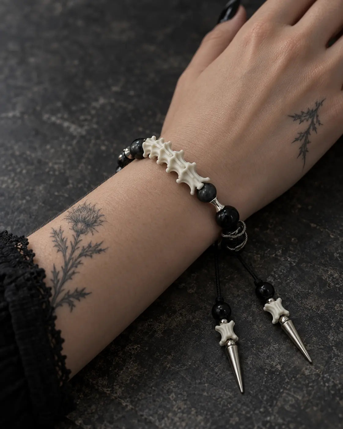 Close-up of the Twin Spike snake bone bracelet showing white vertebrae, dark beads and its hanging spikes