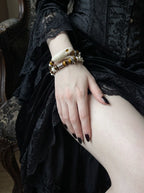 Umberblade Snake Bone Bracelet, white vertebrae and brown bead bracelet worn on a wrist above a black skirt
