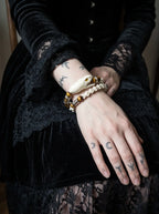 Umberblade Snake Bone Bracelet, amber accented snake bone bracelet worn on a wrist resting against dark fabric