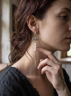 Vajra Spine snake bone earring shown in profile with a hand beneath the chin