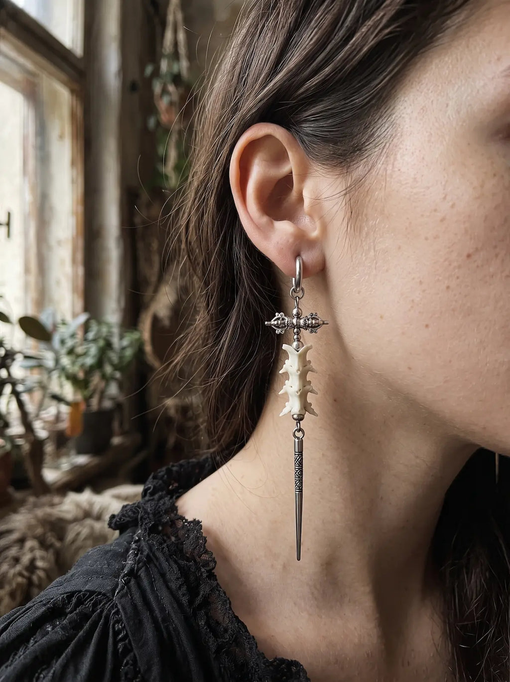 Detailed side view of a Vajra Spine snake bone earring with an ornate crossbar and slender spike