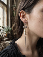 Detailed side view of a Vajra Spine snake bone earring with an ornate crossbar and slender spike