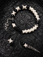 Venom Dagger snake bone bracelet with black beads, a silver-tone snake charm and a long pointed pendant on black cords