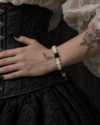 Side view of the Venom Dagger snake bone bracelet with the hand resting across a black corset