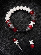 Vermilion Fang snake bone bracelet with red beads, a coiled serpent accent and a pointed metal drop on black cords