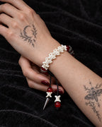 Vermilion Fang snake bone bracelet shown on a wrist supported by the other hand over black fabric