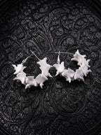 Vertebra Crescent snake bone earrings with open curved rows of white vertebrae and silver-tone hooks on black fabric