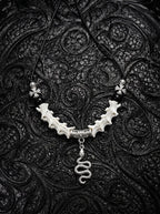 Vesper Serpent Snake Bone Necklace, curved pale snake vertebrae necklace with silver-tone coiled serpent pendant