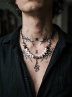 Vesper Serpent Snake Bone Necklace, snake bone and serpent pendant necklace worn against a tattooed chest