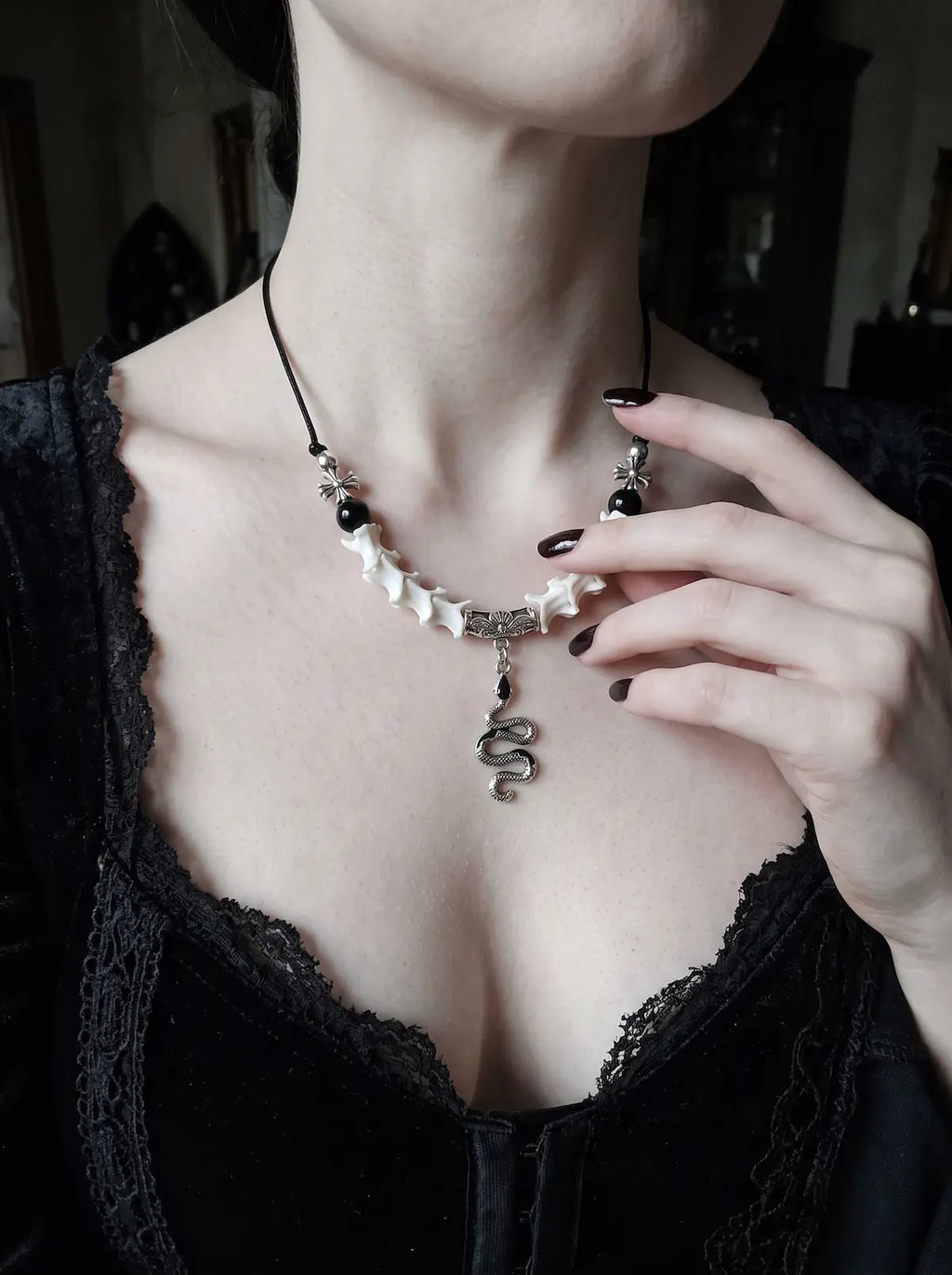 Vesper Serpent Snake Bone Necklace, pale bone necklace and coiled serpent pendant shown on a model in black lace