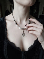 Vesper Serpent Snake Bone Necklace, pale bone necklace and coiled serpent pendant shown on a model in black lace