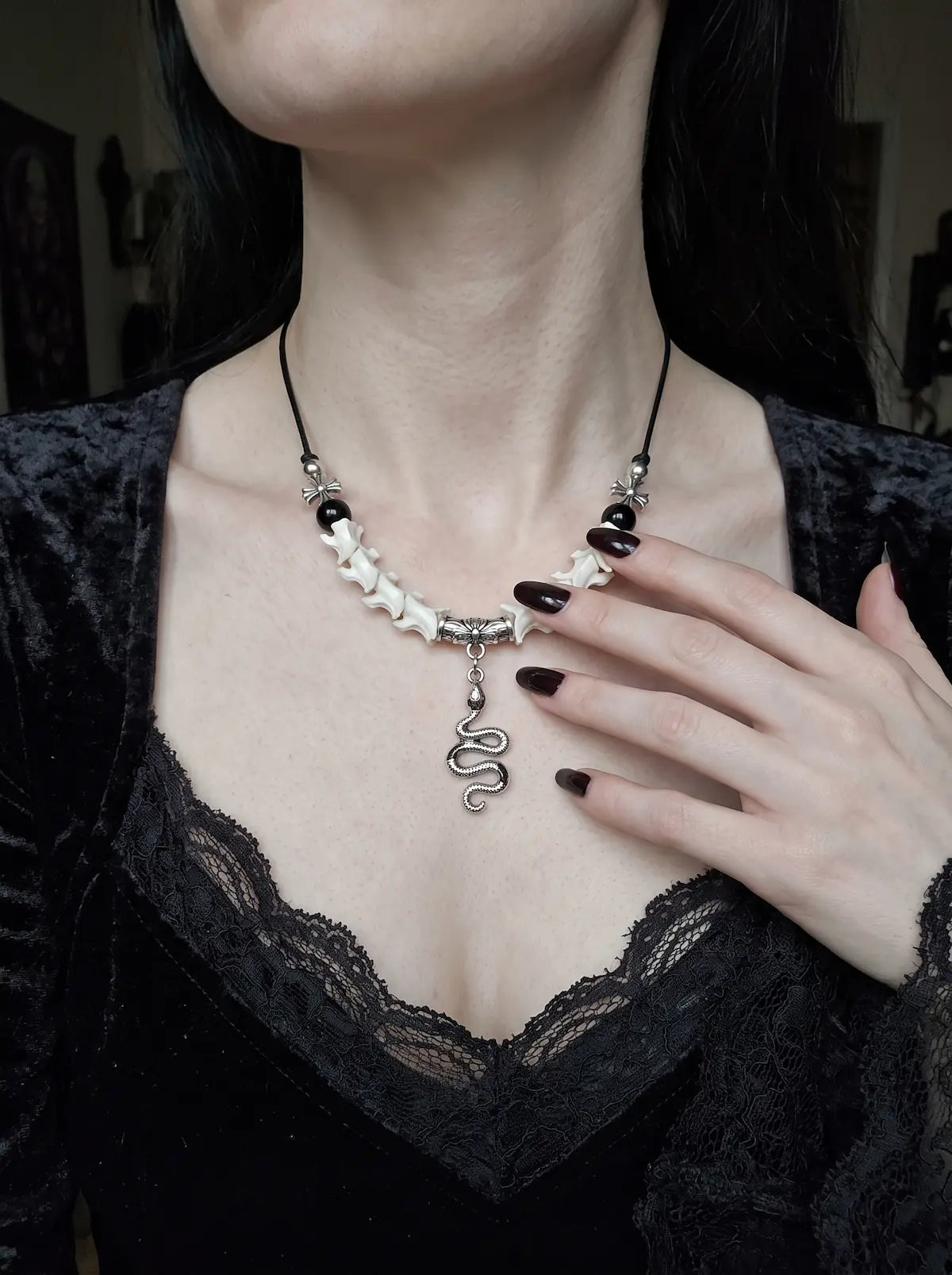 Vesper Serpent Snake Bone Necklace, close front neck view of the serpent pendant and pale snake vertebrae