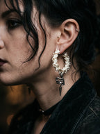 Viper Drop snake bone hoop earring shown in profile against a dark velvet collar