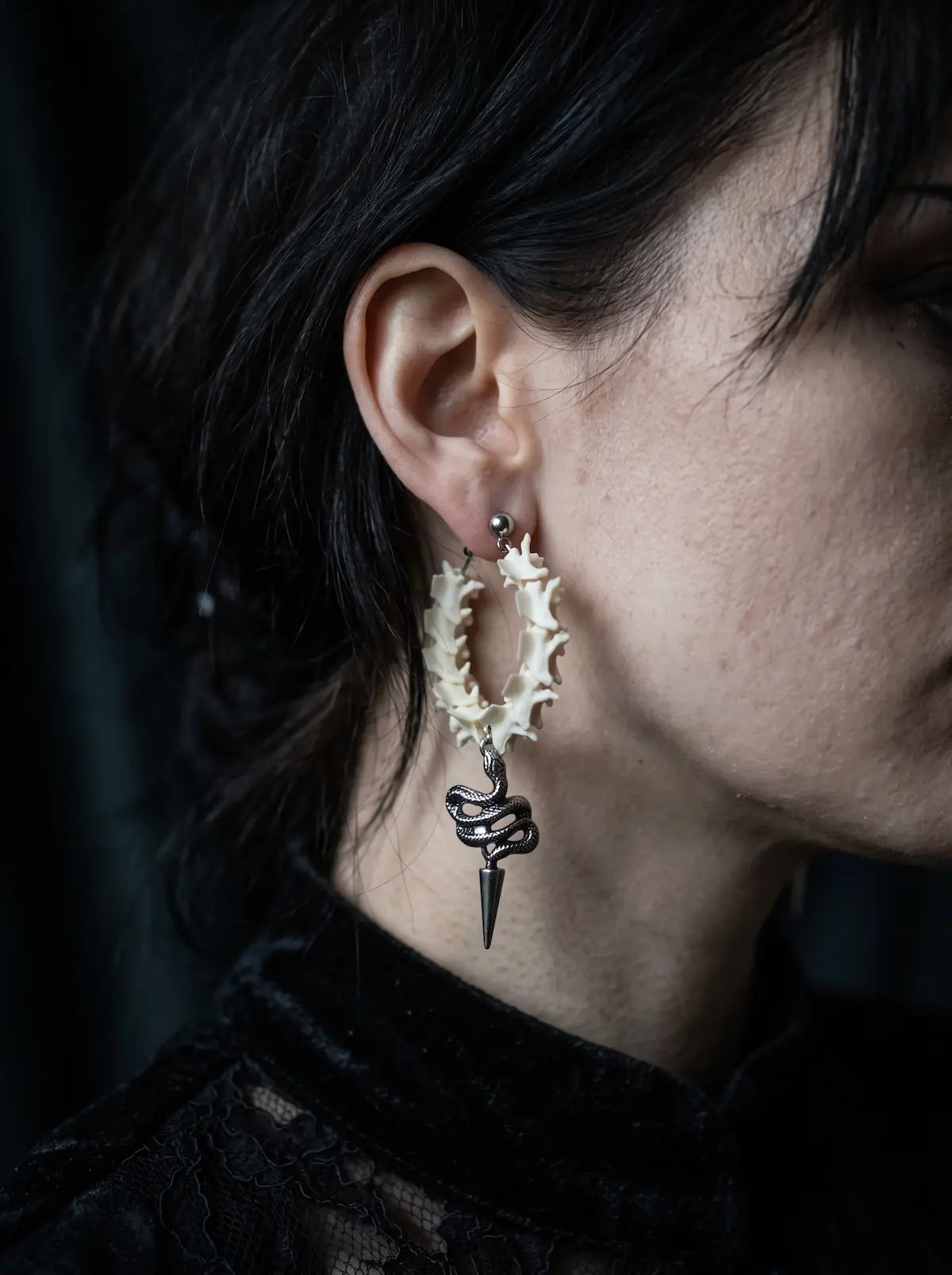 Side view of a Viper Drop snake bone hoop earring showing its coiled snake and spike beneath the hoop