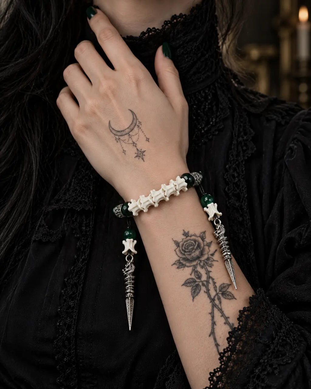 Viridian Wyrm snake bone bracelet worn with the hand at the neck and both pointed drops hanging below