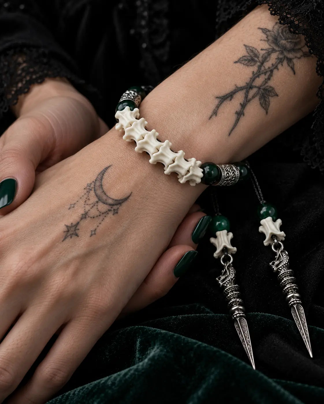 Close-up of the Viridian Wyrm snake bone bracelet showing white vertebrae and engraved silver-tone spacers