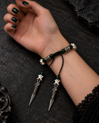 Palm-up view of the Viridian Wyrm snake bone bracelet showing its braided knot and two dragon-headed drops